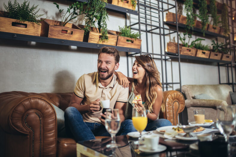 Young happy couple eating pizza in a restaurant