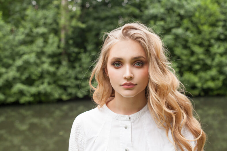 Beautiful woman with blonde hair outdoor, closeup portrait