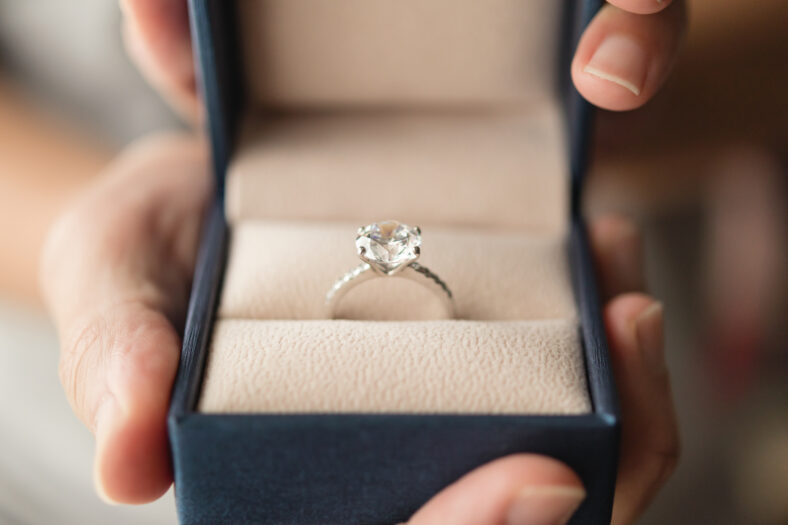 hands holding diamond ring in jewelry box