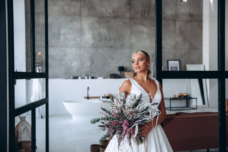 Bride in a white dress with a bouquet of flowers. Wedding preparations. Bride morning.