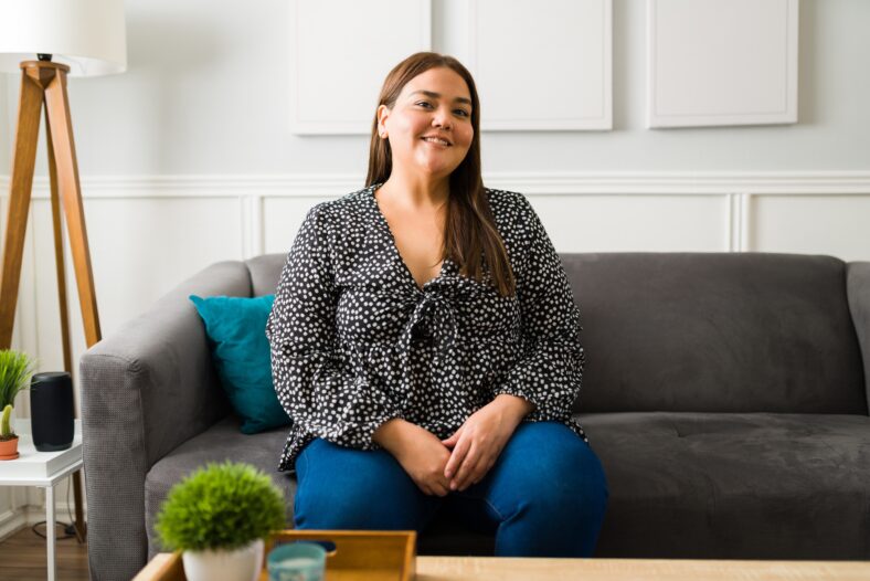 Portrait of an attractive hispanic woman with obesity smiling and feeling positive about herself