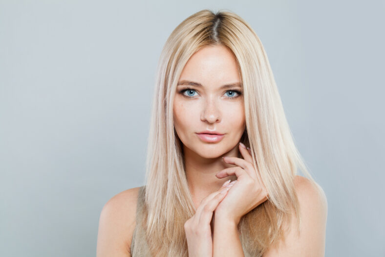 Natural beauty woman face close-up. Blonde model with fresh clear skin and healthy silky hair on white background