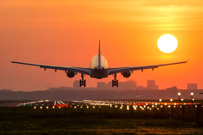 Passenger plane is landing during a wonderful sunrise.