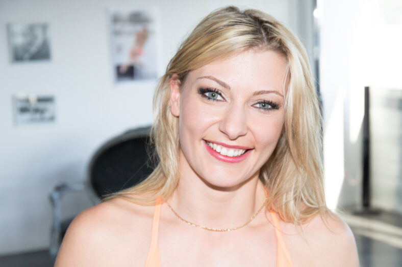 smiling fashion closeup portrait of young pretty woman blond in sport room