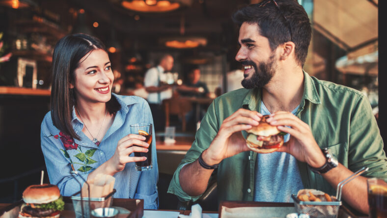 Happy loving couple enjoying breakfast in a cafe. Love, dating, food, lifestyle concept