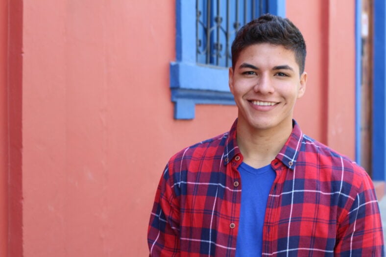 Handsome young hispanic male smiling outdoors