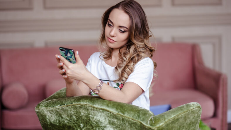 Beautiful young blonde woman with mobile phone. Portrait of pretty blonde girl in casual clothes.