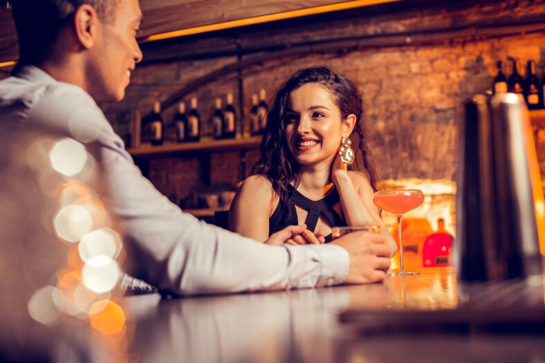 Girlfriend smiling. Beautiful girlfriend smiling while spending time with her loving man in bar