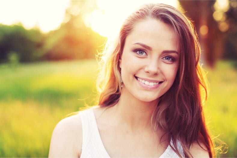 Young woman on field under sunset light