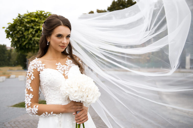 Beautiful bride with a wedding bouquet in their hands outdoors in a park. Wedding day