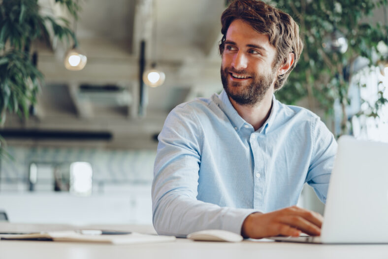 Businessman in shirt working on his laptop in an office. Open space office