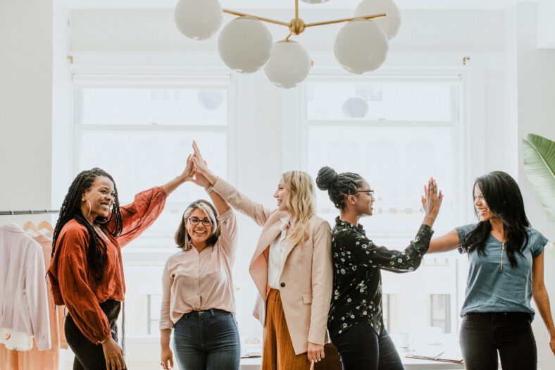 Businesswomen giving a high five to team