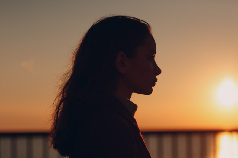 Young beautiful woman profile portrait at sunset