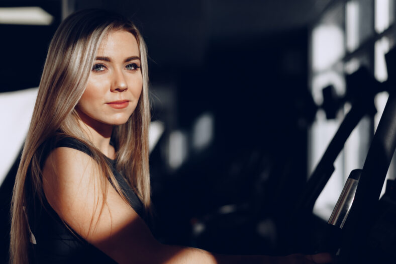 Close up portrait of a beautiful blonde woman with long hair smiling in dark room
