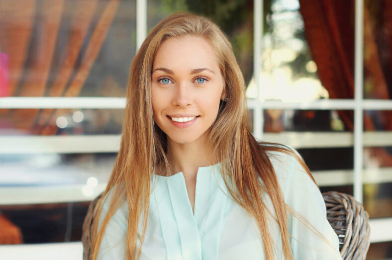 Portrait close up beautiful young blonde woman sitting in a cafe
