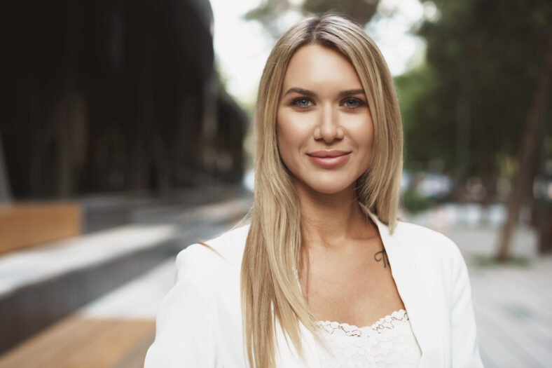 Close up portrait of young businesswoman in white suit going to office