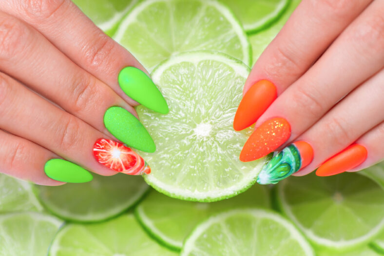 Beautiful female hands with summer manicure nails, orange and green gel polish