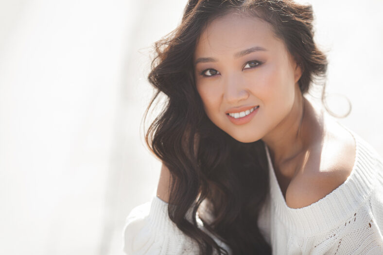 Beautiful woman outdoors. Pretty lady on urban background. Asian female closeup portrait.