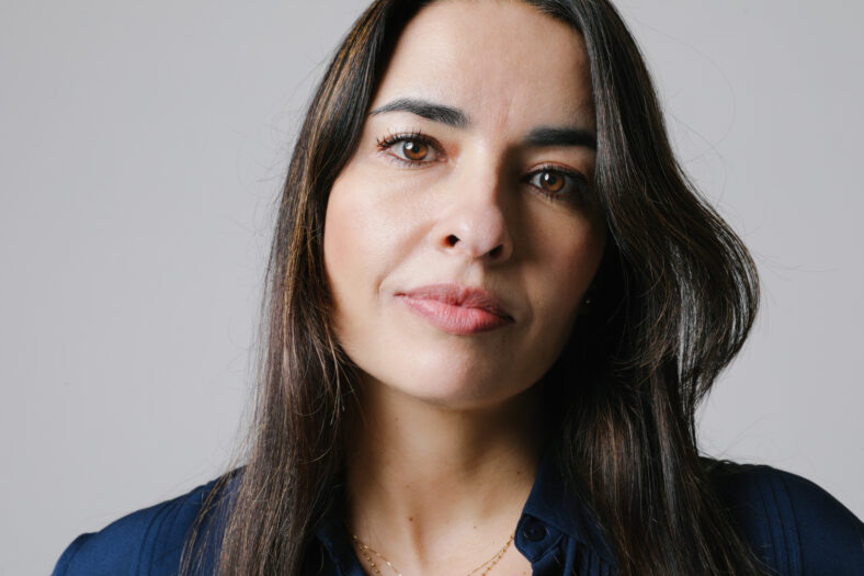 Middle-aged woman smiling friendly and looking in camera. Woman's face closeup. Realistic images with their own imperfections. Selective focus. High quality photo