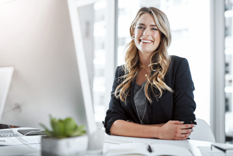 Portrait of a young businesswoman working at her desk in a modern office.