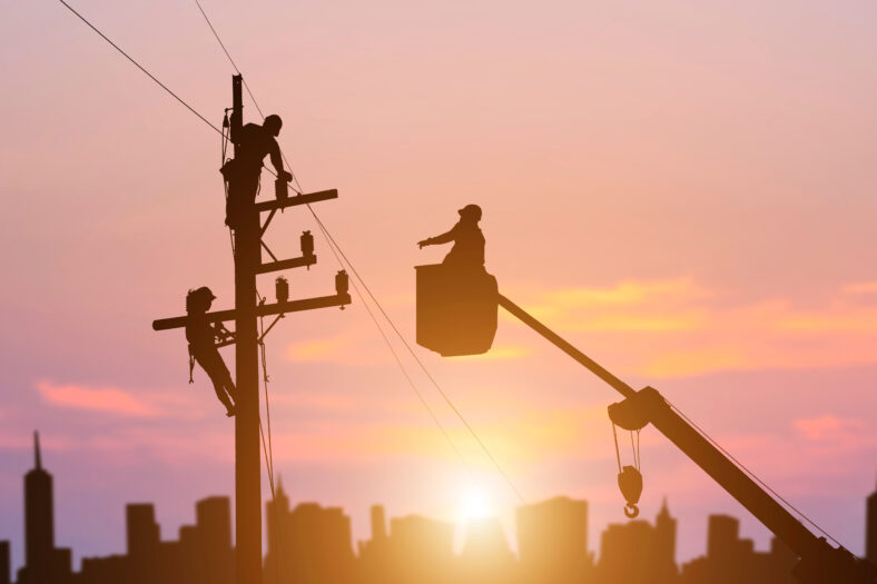 silhouette electrician working on high voltage pole install equipment