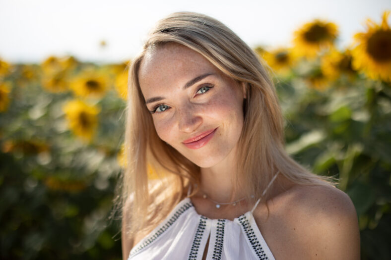 Portrait of a blonde girl close-up on a background of sunflowers