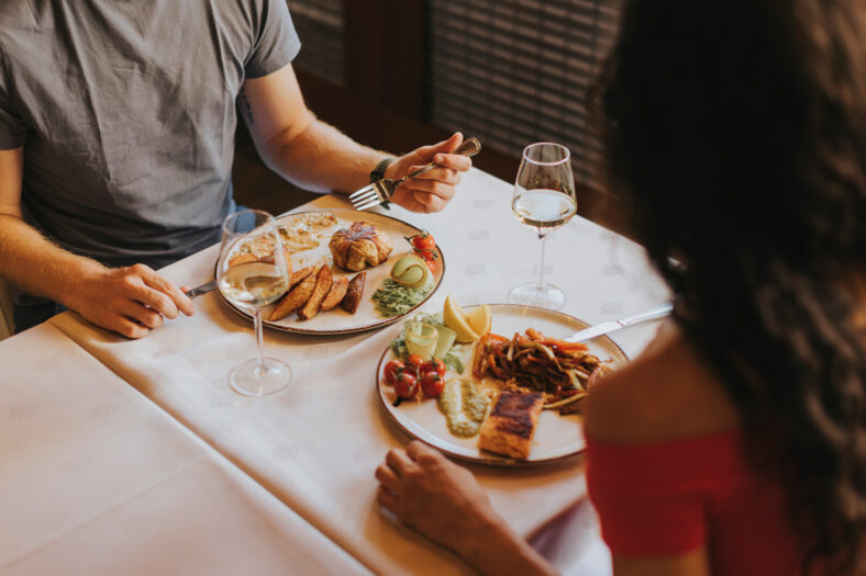Handsome young couple having lunch with white wine in the restaurant