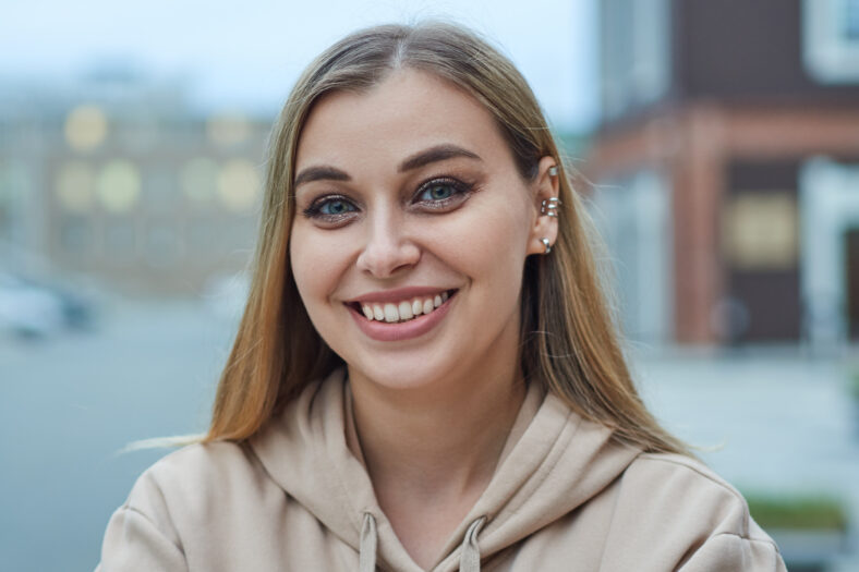 Close-up portrait of a young cheerful girl on the background of the evening city.