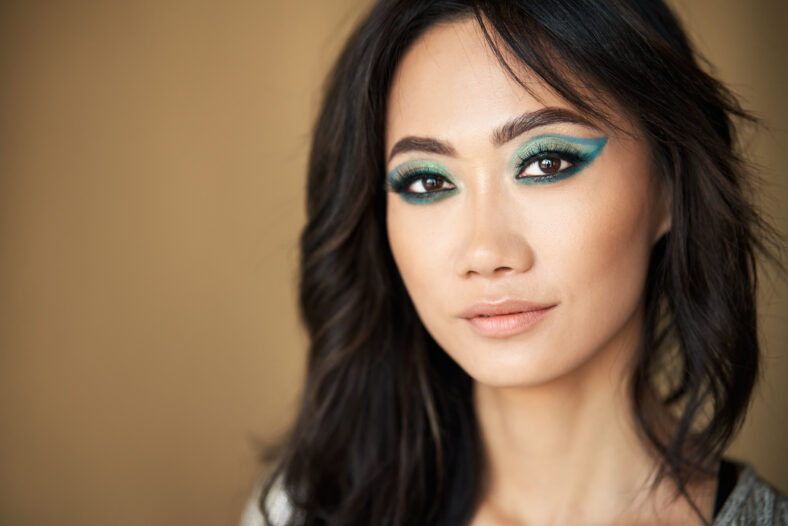 Retrato de la hermosa modelo de chicas asiáticas con cabello largo y maquillaje brillante sobre fondo beige closure