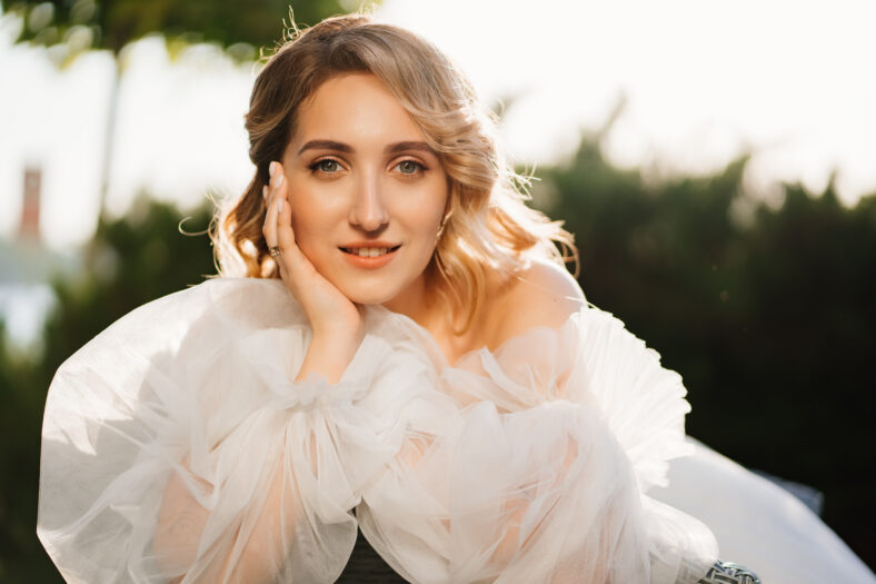 portrait of a beautiful blonde bride in a white dress at sunset. the concept of women's happiness and confidence. professional makeup and cosmetics for weddings