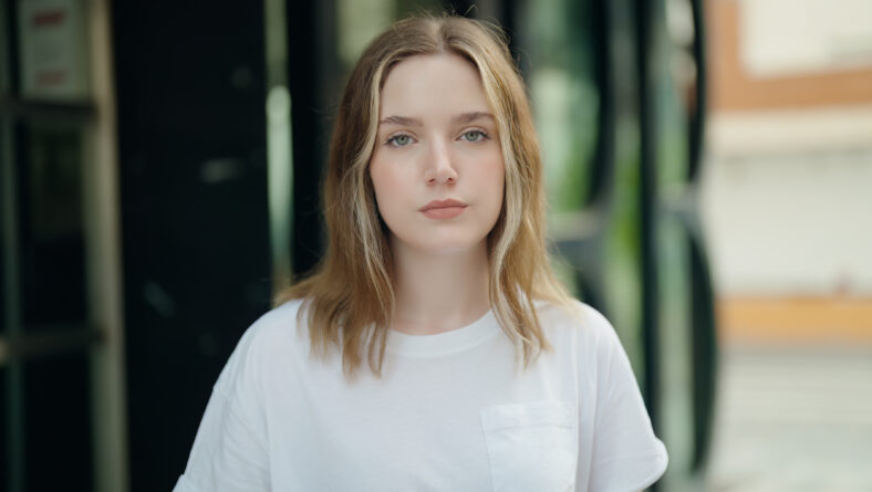 Young caucasian woman standing with serious expression at street