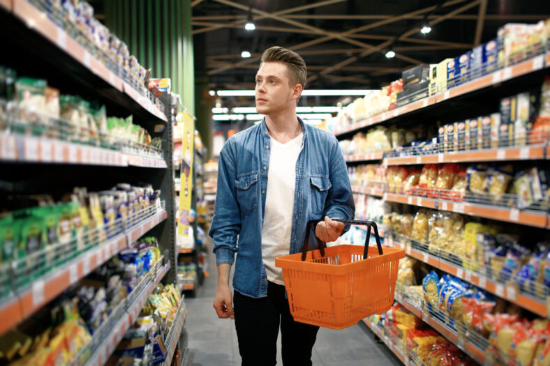 a young man chooses foods at the supermarket