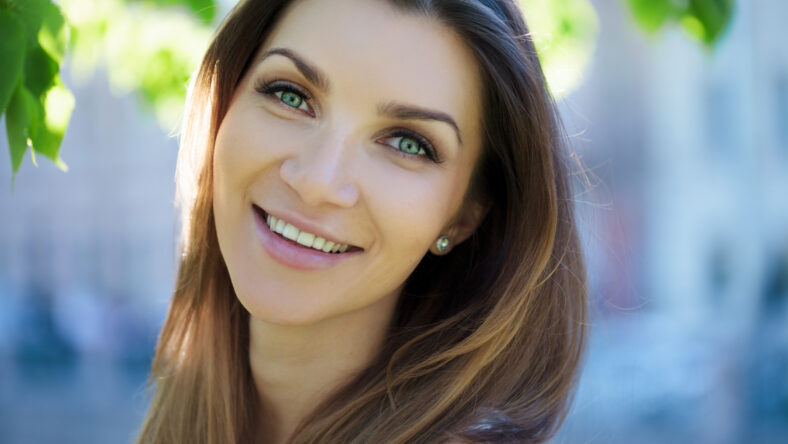 Close-up portrait of a beautiful woman, brunette. On background summer nature