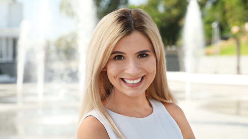 Portrait of beautiful blonde woman outdoors on sunny day