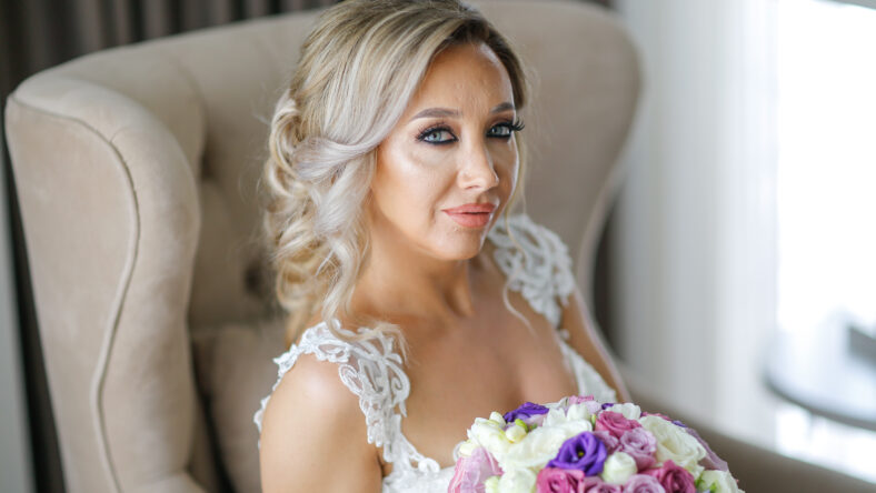 Beautiful blonde bride posing in luxury room