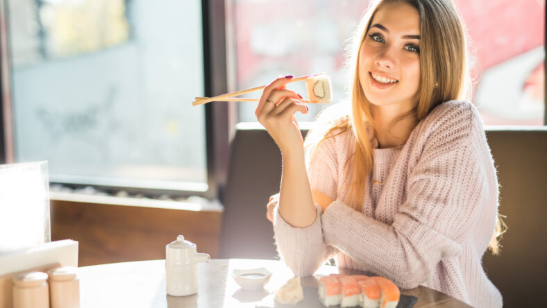 Young woman eating sushi in an Asian restaurant