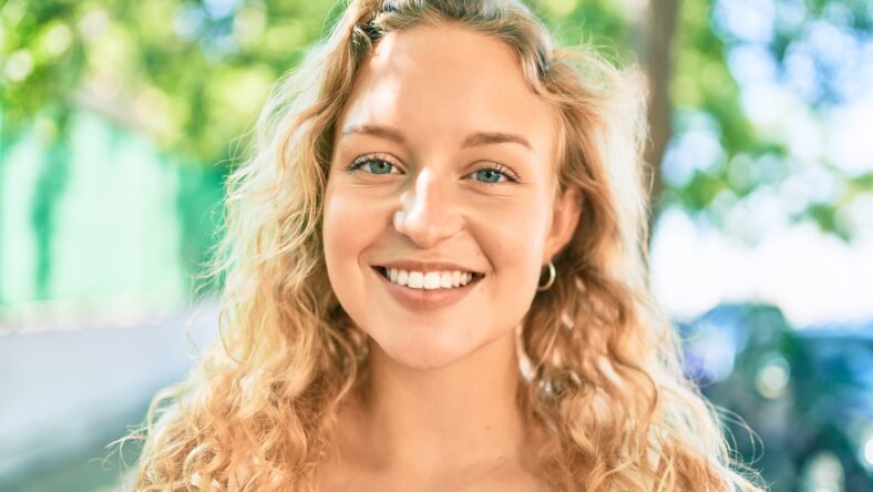 Young beautiful caucasian woman with blond hair smiling happy outdoors on a summer day