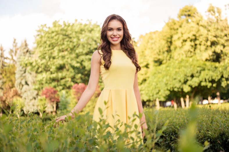 Photo of young attractive woman happy positive smile hands touch plant nature summer season walk park