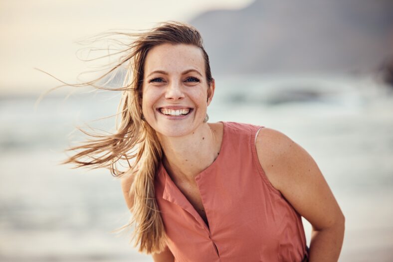 Happy, smile and portrait of a woman at the beach for freedom, travel and peace on holiday in Indonesia. Ocean, happiness and girl by the water at the sea during a vacation to relax in summer.