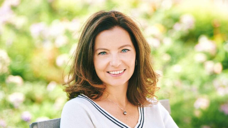 Outdoor portrait of beautiful 40 - 45 years old woman sitting on bench ib green park, healthy lifestyle