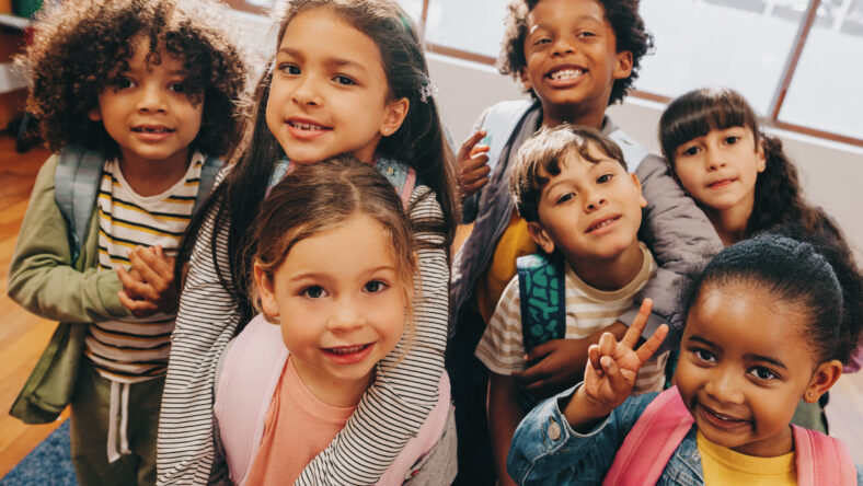 Class selfie in an elementary school. Kids taking a picture together in a co-ed school. Group of elementary school children feeling excited to be back at school.