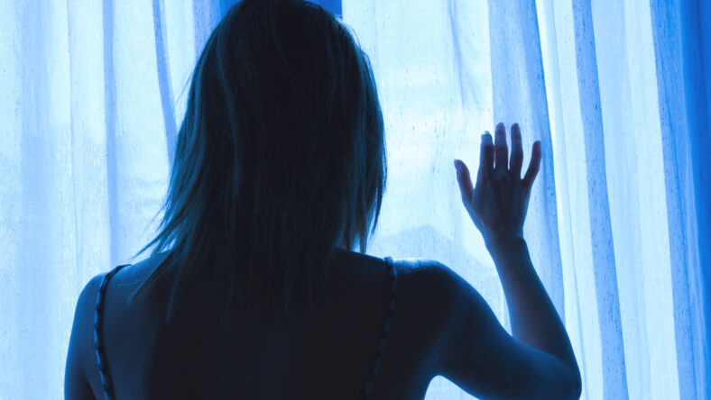 woman looking out the window at night
