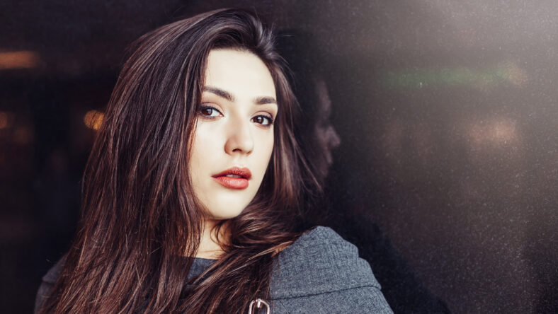 Close up portrait of brunette gorgeous beautiful girl on black background