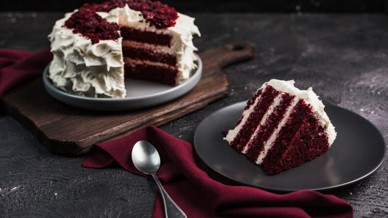 Red velvet cake on dark background, close-up side view. Sweet dessert for the holiday. Copyspace