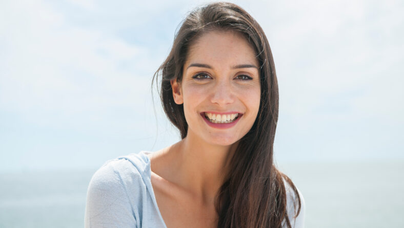 portrait of a beautiful woman before the sea in summertime