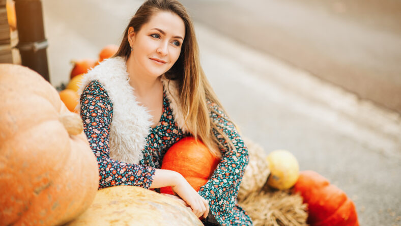 Autumn portrait of young happy woman on farm market