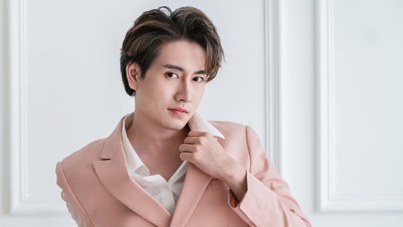Portrait of Korean asian handsome smile friendly Business model man in pink suit sitting , business asian man smart with success, manager or executive with leadership office fashion workspace.
