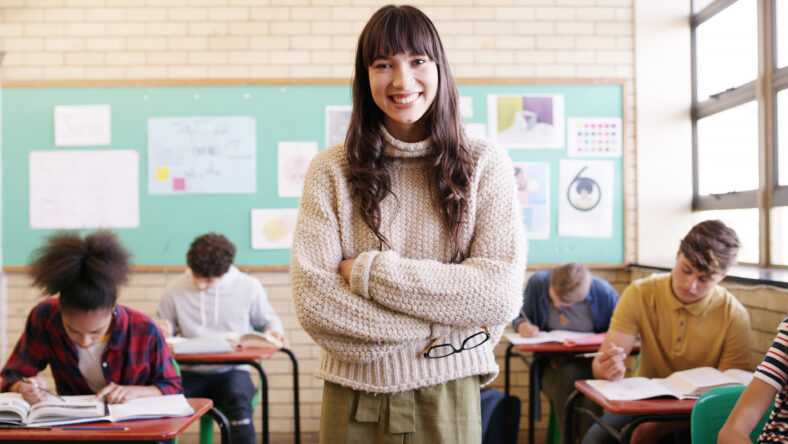 Crossed arms, smile and woman teacher in classroom with confidence for education career. Portrait, knowledge and female educator with pride for job, growth or development at high school or academy