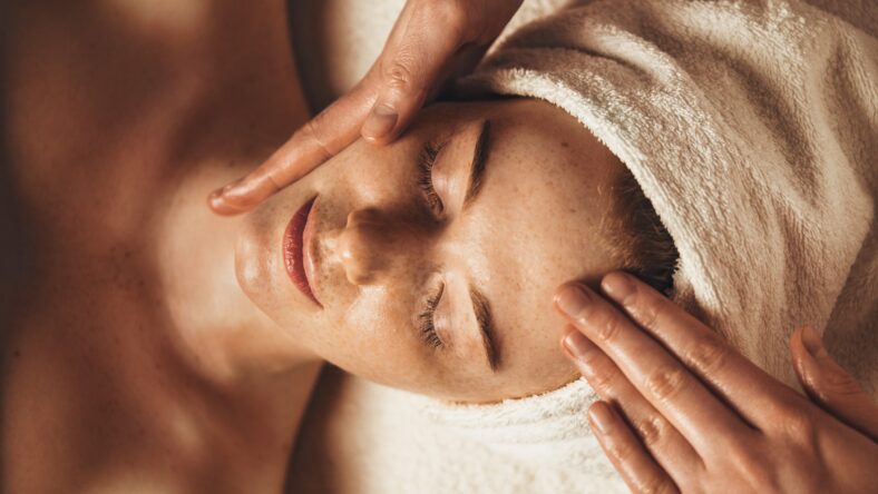 Close-up of young woman getting spa massage treatment at beauty spa salon. Cosmetology beauty skin care anti-aging treatment rejuvenation. Body care, spa. Facial beauty. Woman beauty face. Healthy lifestyle.