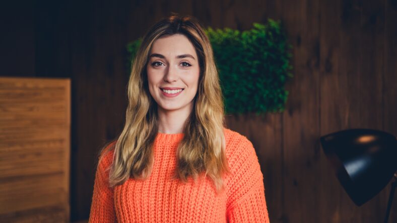 Photo of nice young girl look camera smiling wear orange clothes enjoy modern cozy interior flat indoors.